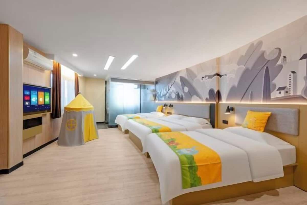 Una habitación de hotel con cama, mesitas de noche, televisor y una obra de arte colgada en la pared.