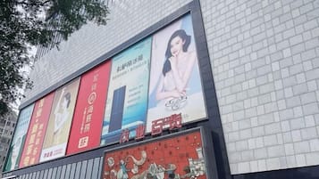 A building facade with multiple advertisements, including a prominent red banner and a blue banner with a woman.