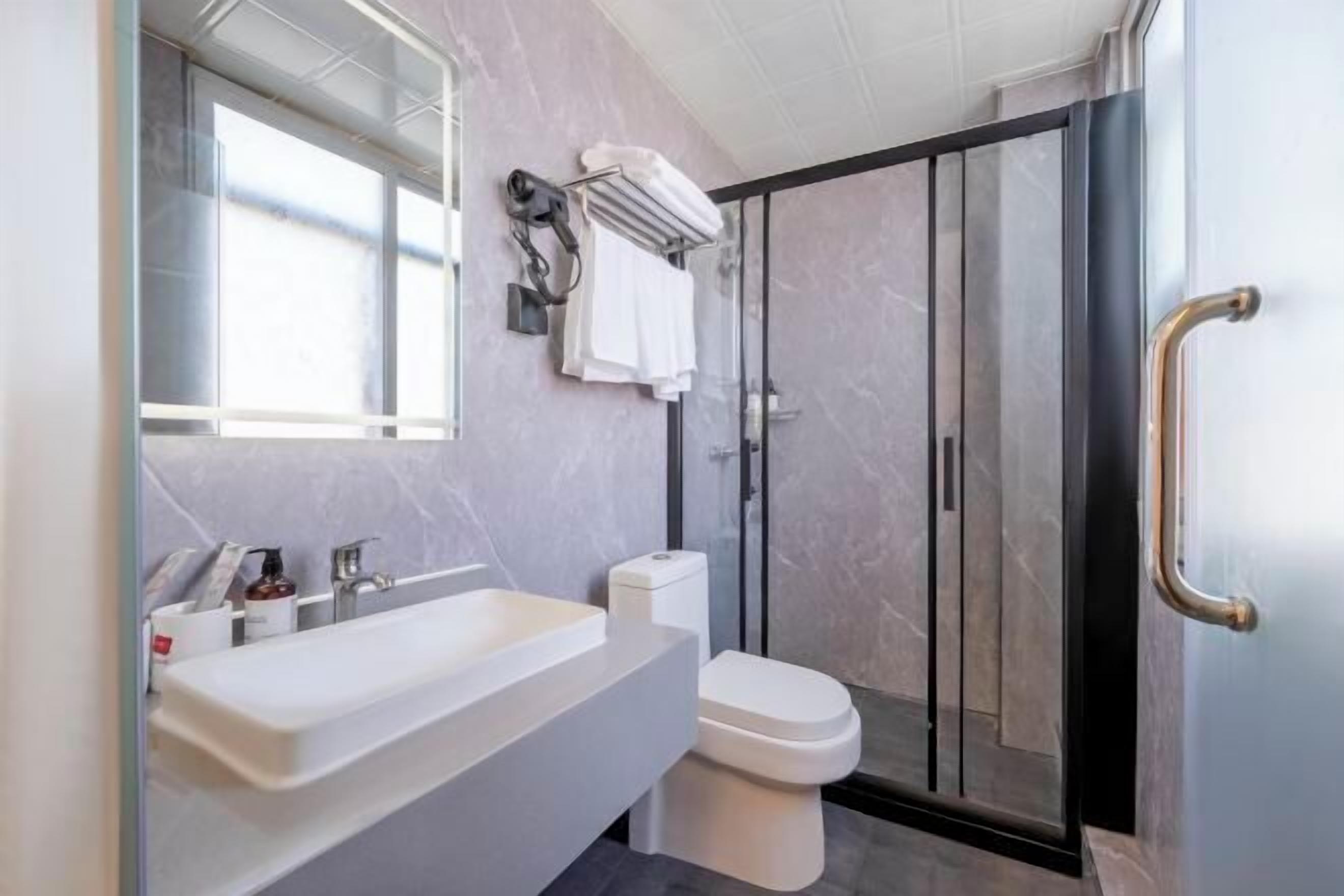 A modern bathroom with a large bathtub, a toilet, and a glass-enclosed shower.