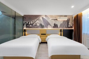 Una habitación de hotel con dos camas, un mural grande en la pared y una ventana con cortinas.