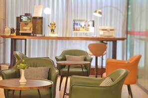 A bar area with leather chairs, a round table, and a bar counter with a television and decorative items. - Chengdu Eight Treasures Hotel(Kuanzhai Alley Luomashi Subway Station) (Chengdu)