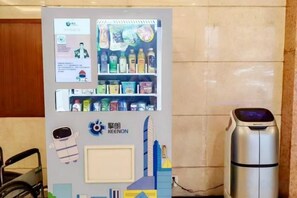 Ein Getränkeautomat mit verschiedenen Artikeln, einem Wasserkocher und einem Schild mit Text und Grafiken.