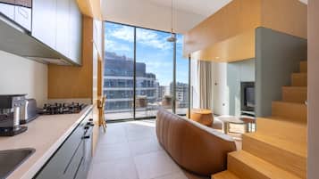 A modern kitchen with a large window, a sofa, and a dining area.