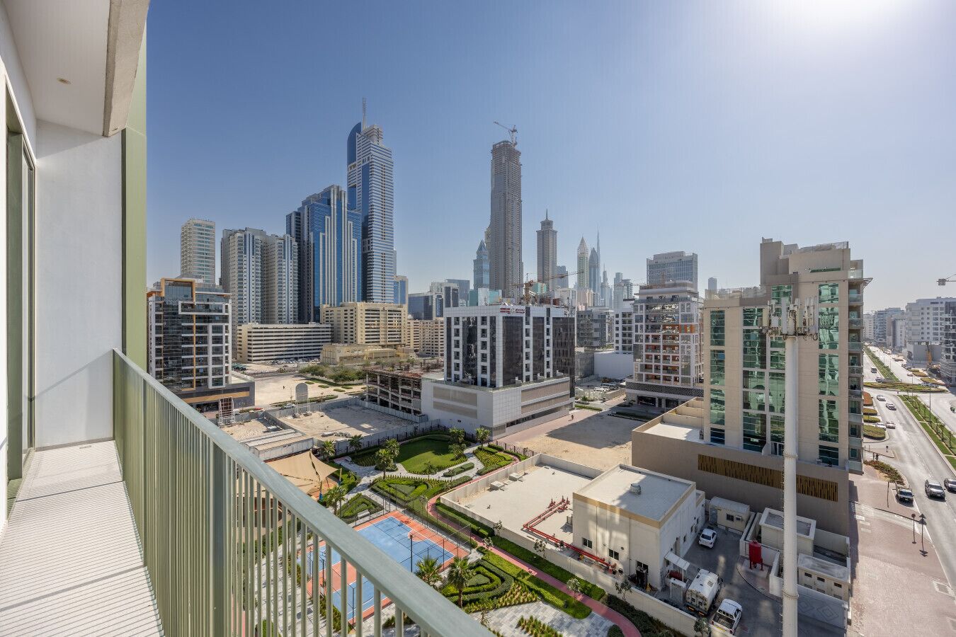 A high-rise building with a modern architectural design, featuring a mix of glass and concrete facades, and a rooftop garden.