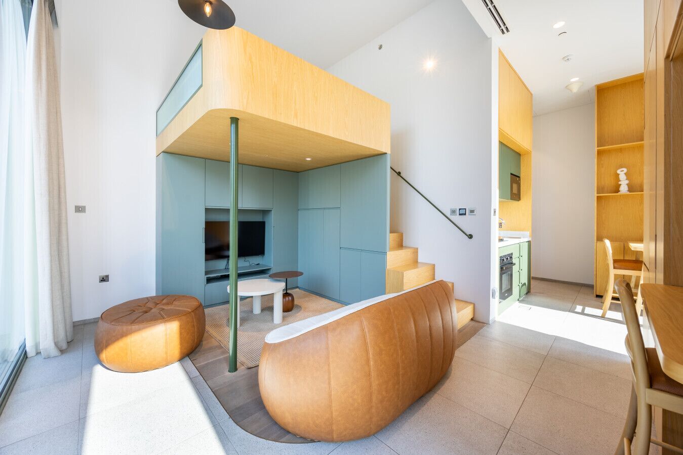 A modern living space with a loft area, a dining area, and a kitchen.