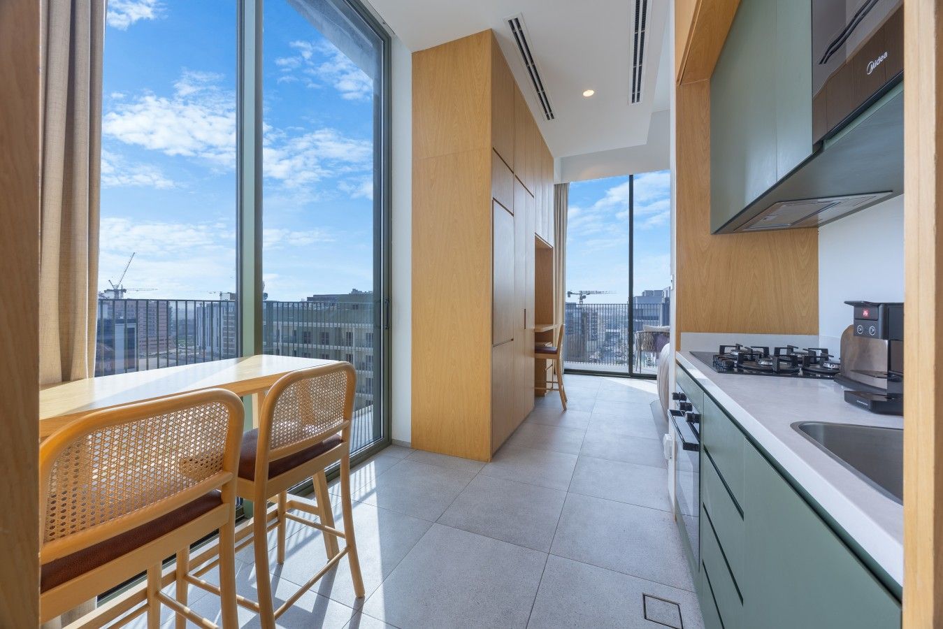A modern kitchen with a view of the city skyline, a dining area with a table and chairs, and a large window.