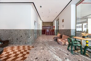 A modern lobby with a checkered carpet, seating area, and a reception desk. - Mood 45 - Deluxe Studio: Your Perfect Getaway (Jumeirah Garden City)