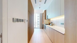 A modern kitchen with a central island, built-in appliances, and a view to the outside. - Mood 45 - Deluxe Studio: Your Perfect Getaway (Jumeirah Garden City)