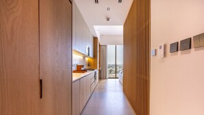 A modern kitchen with wooden cabinets, a countertop, and a view to the outside.