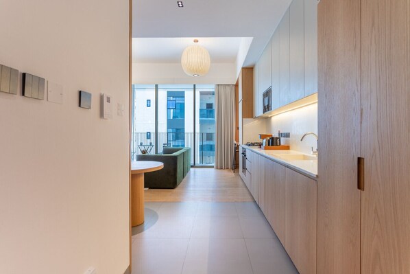 A modern kitchen with wooden cabinets, a round dining table, and a view to the outside.
