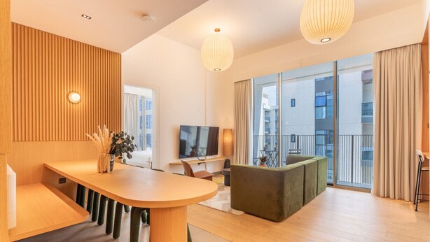 Un salon moderne avec une table à manger en bois, un canapé et un téléviseur.