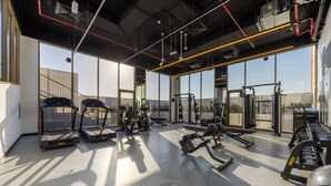 Une salle de sport moderne équipée de tapis de course, d’appareils de musculation et de tapis d’exercice.