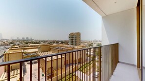 Un balcon donnant sur un paysage urbain, avec vue sur les bâtiments et les rues.