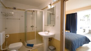 Een badkamer met toilet, wastafel, douche en een spiegel.