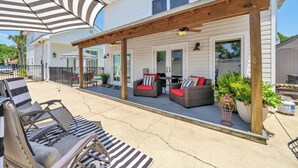 A covered patio area with outdoor furniture, a pergola, and a pool.