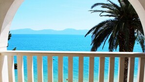Un balcón con vista al mar y a las montañas.