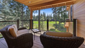 A covered outdoor area with wicker furniture and a view of a forest. - Suncadia-luxury 4bd ensuite spa retreat & on-site EV charger on Prospector 13. A (Cle Elum)