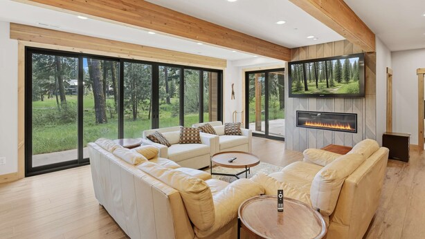 A modern living room with a fireplace, large windows, and a television. - Suncadia-luxury 4bd ensuite spa retreat & on-site EV charger on Prospector 13. A (Cle Elum)