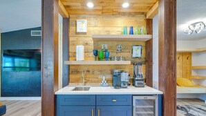 A compact kitchen with wooden accents, a built-in sink, and a coffee maker. - Canal-Front Gem w/ Hot Tub, Foosball in Cape Coral (Cape Coral)