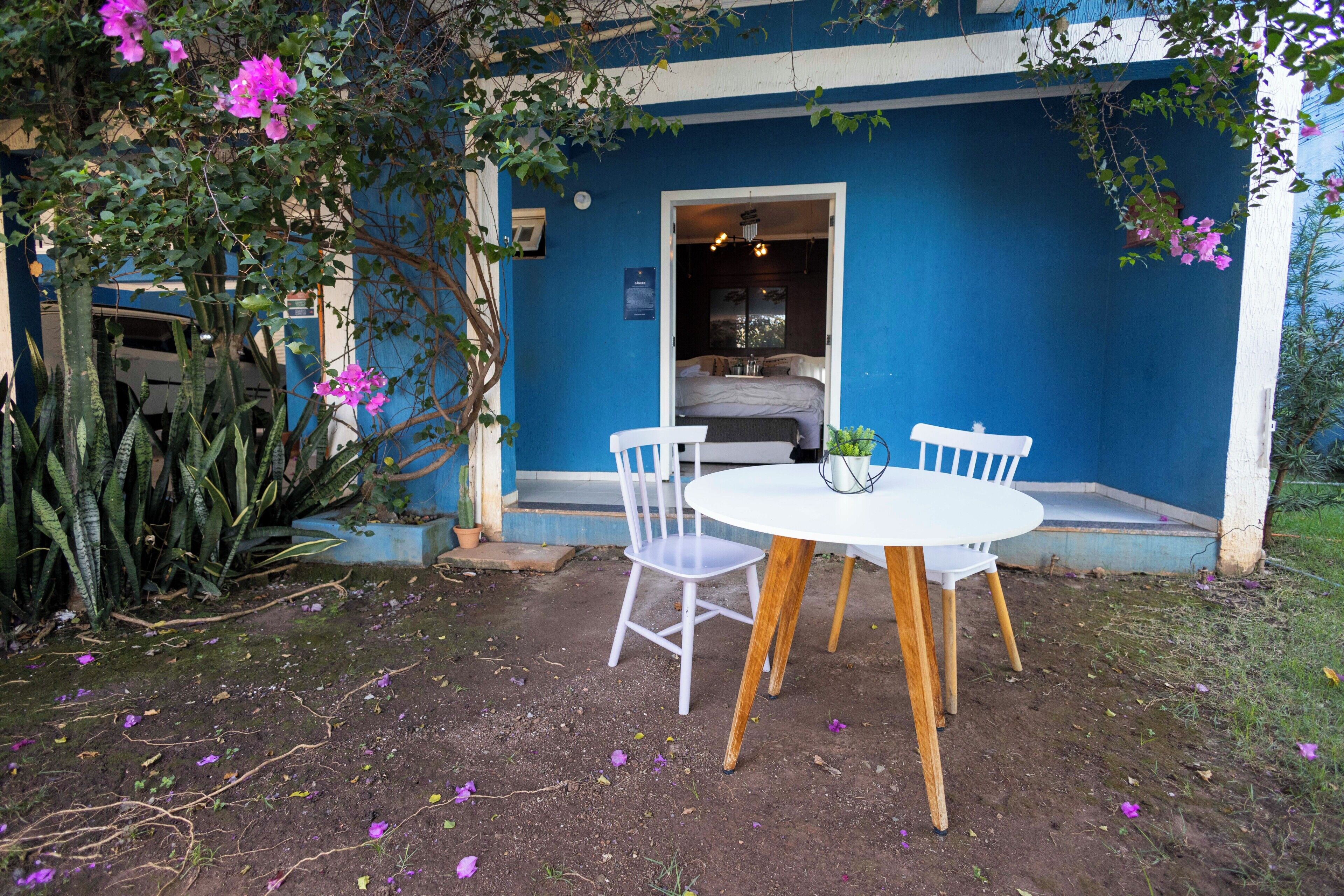 A blue exterior wall, a white door, a bed, and a table with chairs.