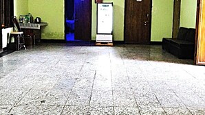 A spacious lobby with a tiled floor, two ceiling fans, and a reception desk with a computer and a small table. - Hotel Radhey inn (Kanpur)