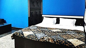 A bedroom with a bed, a nightstand, and a wardrobe. - Hotel Radhey inn (Kanpur)