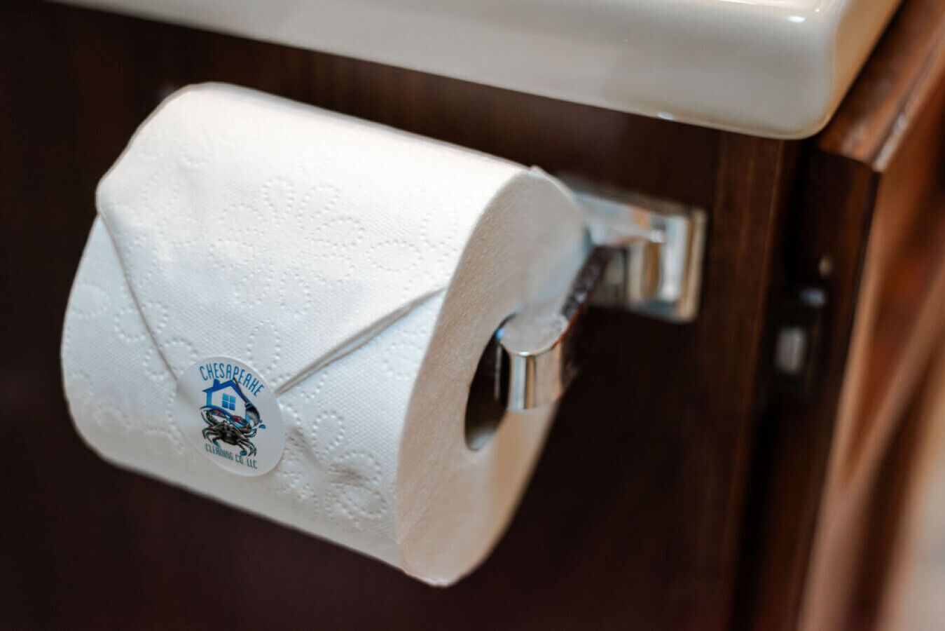 A toilet paper roll mounted on a metal holder attached to a wall.