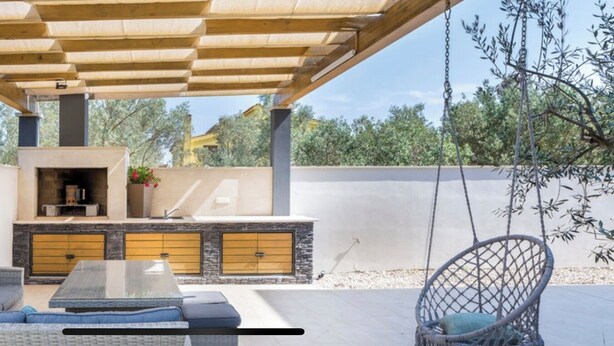 An outdoor patio with a sofa, a table, and a hanging chair. - Villa Fažana (Fažana)