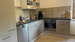 Una cocina moderna con lavavajillas, estufa y armarios.