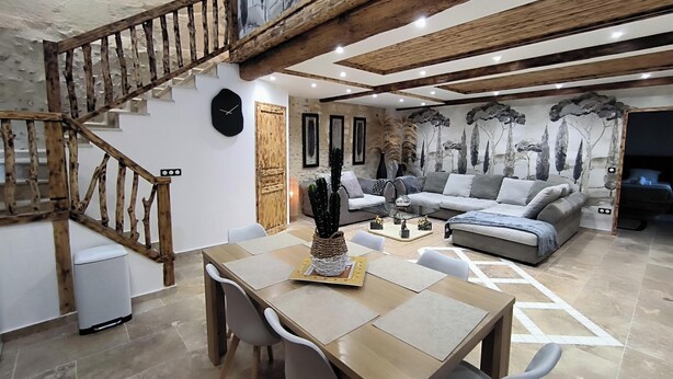 A modern living room with a wooden staircase, a dining area, and a sofa set. - Villa Blanche Domaine de la Tapie de Bouchet - in the Camargue (Arles)