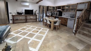 A modern kitchen with wooden accents, a dining area with a table and chairs, and a staircase. - Villa Blanche Domaine de la Tapie de Bouchet - in the Camargue (Arles)