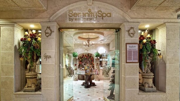L’entrée du Serenity Spa by Westgate se distingue par une imposante arche, un lustre et des décorations florales.