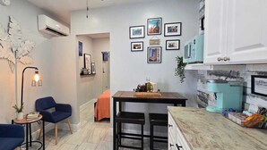 A compact living space with a kitchenette, a dining area, and a seating area with two chairs.