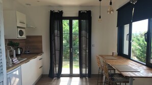 A modern kitchen with a wooden countertop, a built-in microwave, and a window with curtains. - Gite for 2, in the countryside, 15 minutes from the medieval town of Carcassonne (Verzeille)