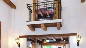 A spacious living room with a high ceiling, a balcony, a white sofa, a coffee table, and a fireplace. - Espectacular La Casita Cartagena (Cartagena)