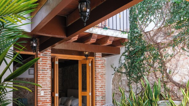 A pool area with a hammock, two chairs, and a view of a bedroom. - Espectacular La Casita Cartagena (Cartagena)