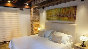 A neatly made bed with white linens, a headboard, and a bedside lamp. - Espectacular La Casita Cartagena (Cartagena)