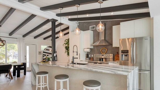 A modern kitchen with a marble island, stainless steel appliances, and pendant lighting. - Luxury Waterfront Home w/ Pool, Hot Tub & Dock Near Las Olas Gulfstream (Fort Lauderdale)