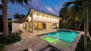 A modern house with a swimming pool, large windows, and a covered patio area. - Luxury Waterfront Home w/ Pool, Hot Tub & Dock Near Las Olas Gulfstream (Fort Lauderdale)