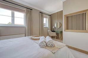 Enjoy a restful stay in this stylishly appointed room featuring a comfortable bed, desk, and mirror.