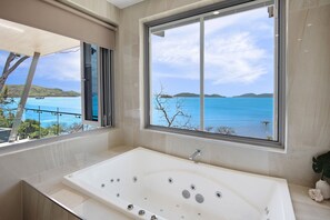 Relax in a spacious bathroom with a bathtub and scenic views.