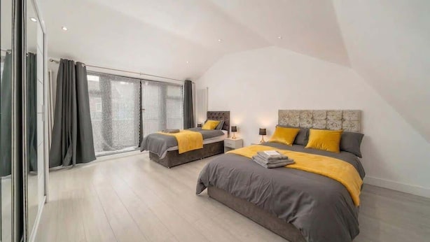 Un dormitorio moderno con dos camas, un ventanal y vistas al exterior.