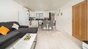 Una sala de estar moderna con sofá, mesa de centro y comedor con sillas y una mesa.