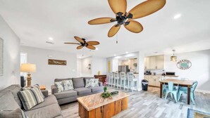 Una sala de estar moderna con sofá, mesa de centro y ventiladores de techo.
