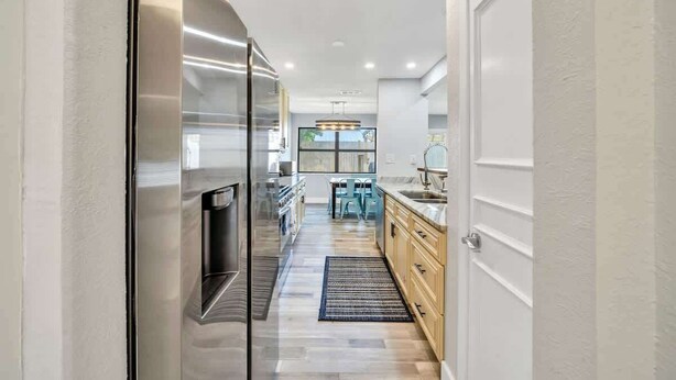 Una cocina moderna con electrodomésticos de acero inoxidable, armarios de madera y una isla central.