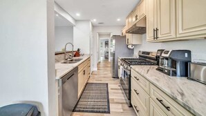 Una cocina moderna con armarios de colores claros, electrodomésticos de acero inoxidable y una encimera de mármol.