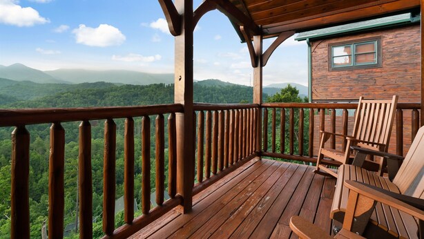 Una terraza de madera con vistas a una cadena montañosa boscosa.
