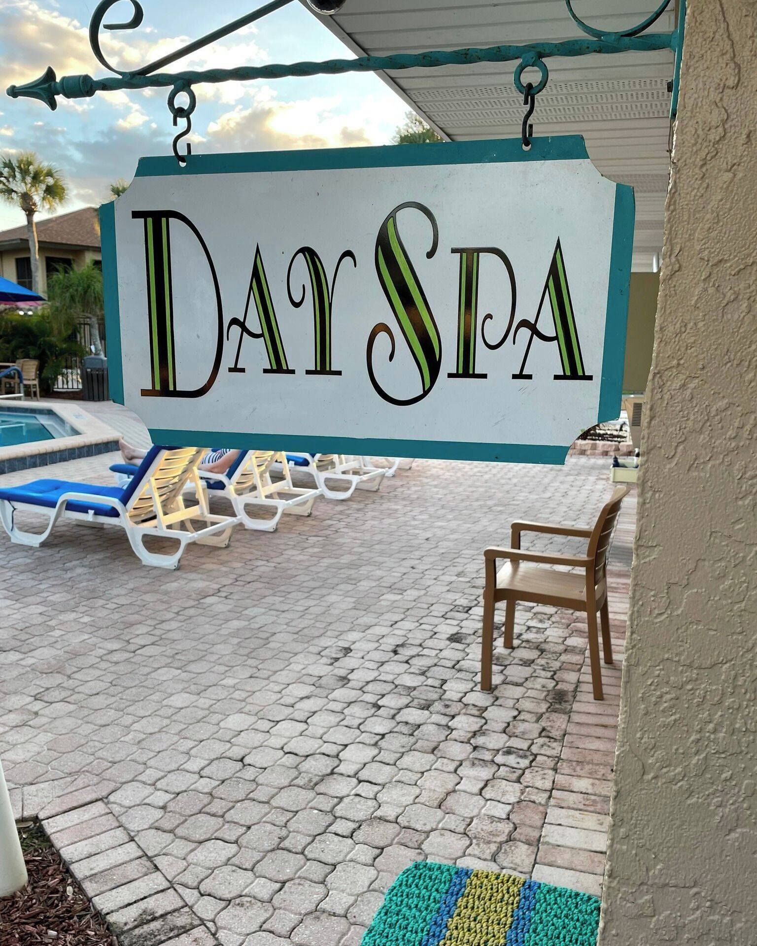 A pool area with lounge chairs and a sign reading "DaySpa".