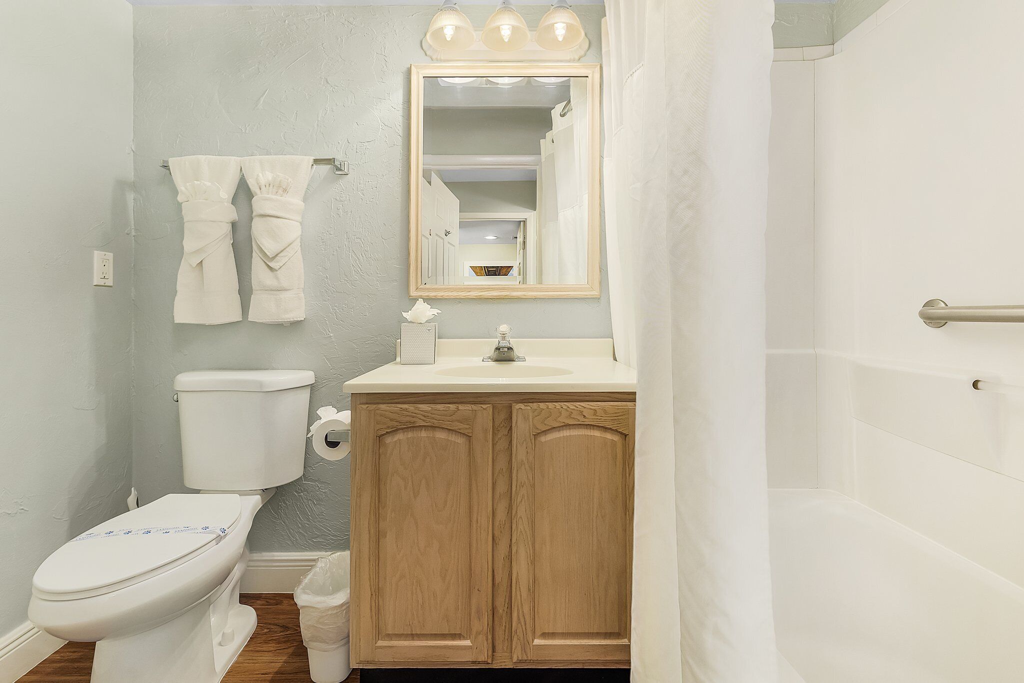 A bathroom with a toilet, sink, and shower.
