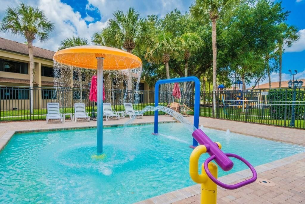 Een buitenzwembad, parasols bij het zwembad en ligstoelen